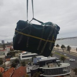 Melbourne Removalists - Crane Loading Furniture Off a Balcony - 7 Floors to Ground